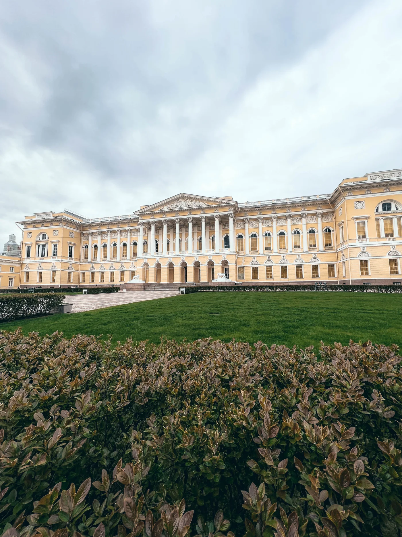 Фасад Михайловского дворца за газоном и кустарником