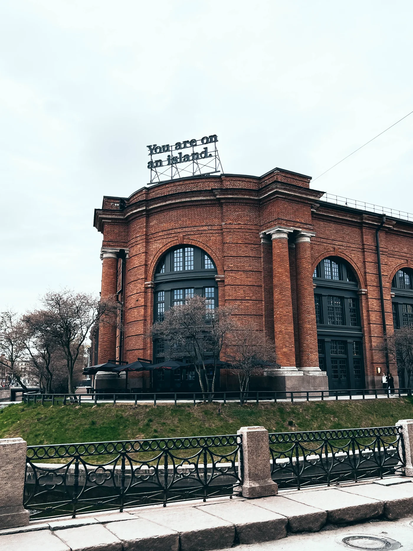 Высокие арочные окна кирпичного здания у канала