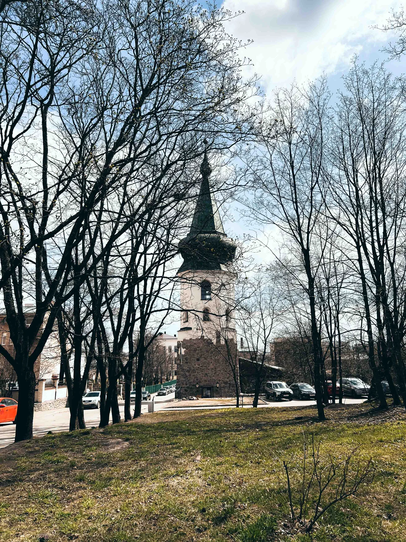Силуэт башни за деревьями у улицы